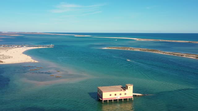 Aerial view. Drone flight over the natural Portuguese park Ria formosa over the village of Fuseta. Rescue house in the middle of a bay with turquoise water