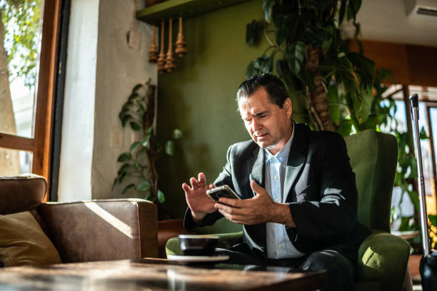 istock Mature businessman using mobile phone at a coffee shop 1474237715