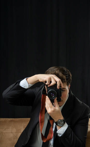 istock photographer in suit taking pictures with his retro camera 1474240621