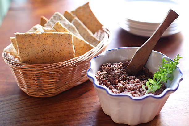 Tapenade olive spread with poppyseed crackers stock photo