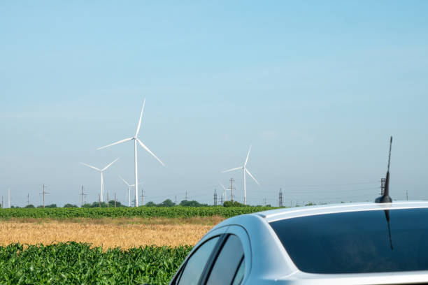 istock Electric car against wind turbines on unoccupied site 1474244236