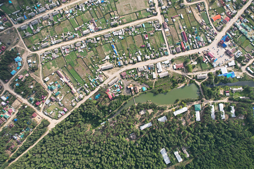 Countryside in summer. Aerial view of a village with small houses, vegetable gardens and a small pond.