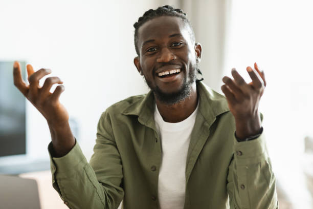 istock Cheerful african american man talking to camera and gesturing, having video call while sitting at home 1474251125