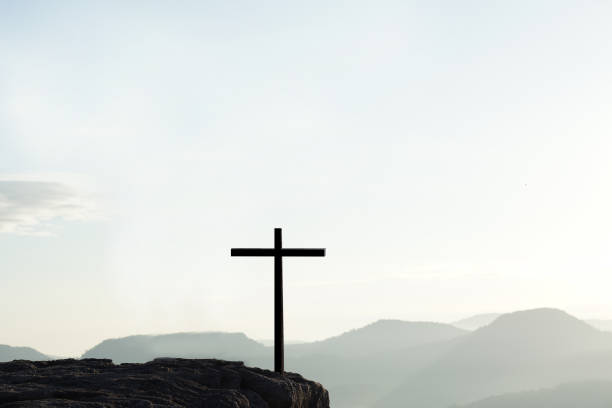 istock Cross silhouette on mountain nature background 1474265578