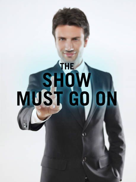 Businessman touching “The show must go on” on virtual screen.