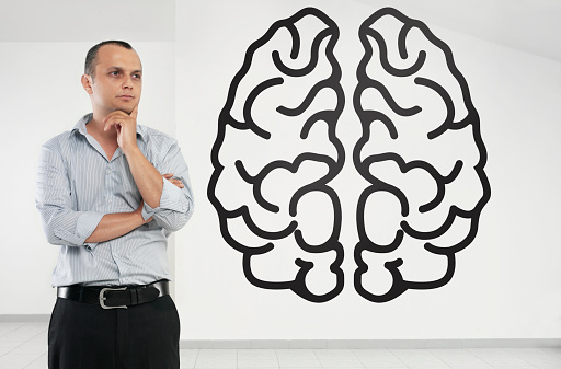 Businessman looking at human brain icon on a touch screen