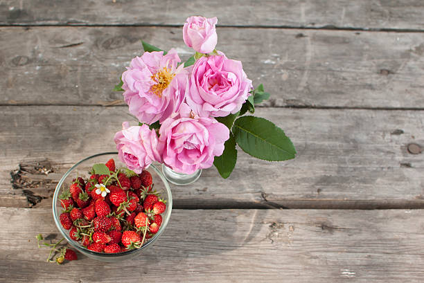 istock tea roses bunch and wild strawberry at table 147427105