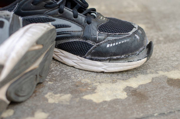 istock broken old black sneakers on the floor 1474279256