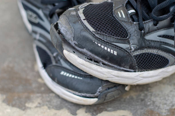istock Close up. broken old black shoes on the floor 1474279263