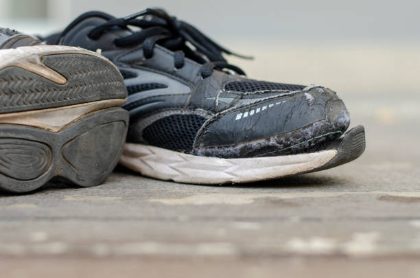 istock Old black sneakers torn after a long time of use. 1474279265