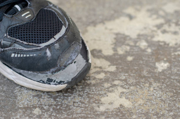 istock Top view broken old black canvas shoes on the floor. copy space 1474279299