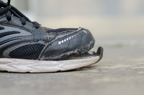 istock side view broken old black canvas shoes on the floor. copy space 1474279315