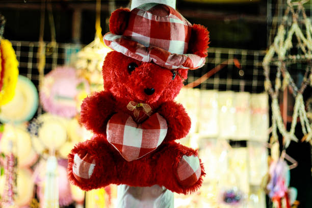 istock A red teddy bear with a plaid hat and a plaid hat hangs on a pole. 1474283645