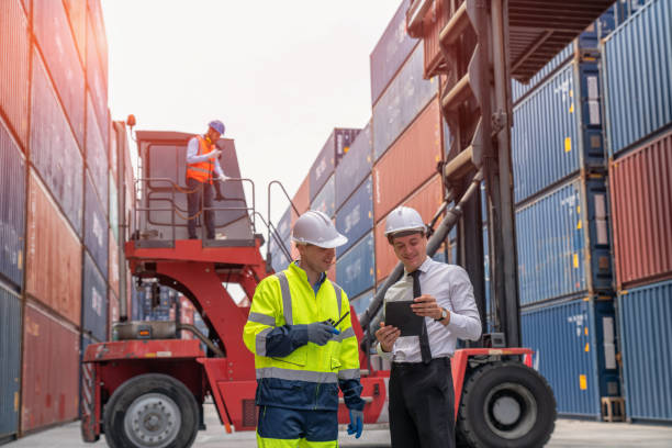 istock Engineers are overseeing the transportation of cargo with containers inside the warehouse. Container in export and import business and logistics. 1474284741