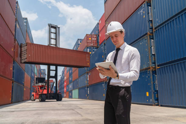 istock Engineers are overseeing the transportation of cargo with containers inside the warehouse. Container in export and import business and logistics. 1474284745