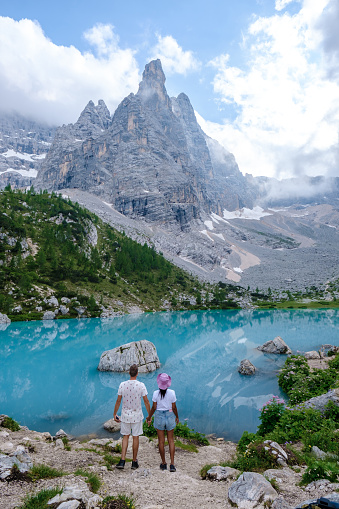 Lago di Sorapis in the Italian Dolomites, milky blue lake Lago di Sorapis, Lake Sorapis, Dolomites, Italy during summer, couple hiking in the Italian mountains of the Dolomites