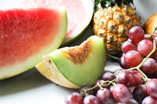 close up of fruits such as melon, pineapple, grapes, and watermelon