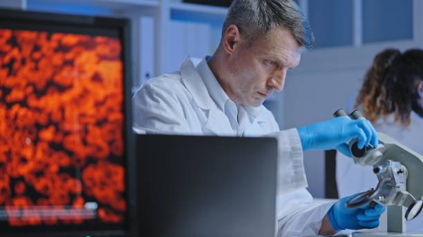 istock Scientist adjusting microscope to examine blood sample, diagnostics and treatment 1474299308