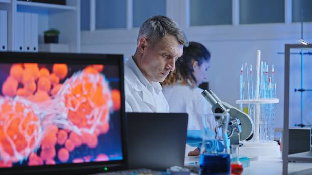 istock Virology scientist conducting research, studying infected cell under microscope 1474299349