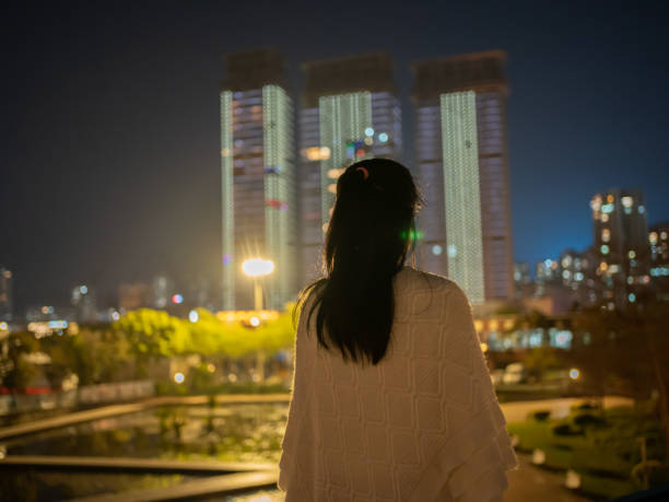 istock woman looking at city night view 1474305514