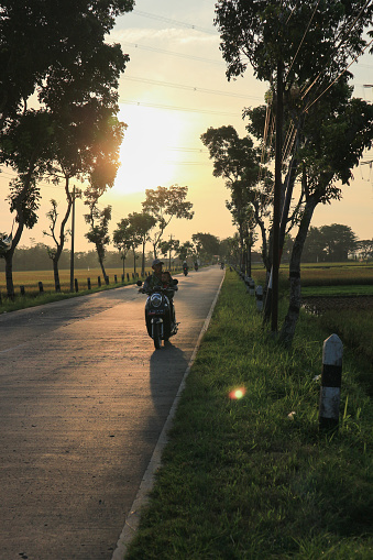 Cilacap 15 March 2023 : Evening atmosphere on the highway with several motorbike riders carrying out life activities and routines