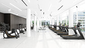 Modern Gym Interior With Treadmills, Exercise Bikes, Sports Equipments And City View Through Window