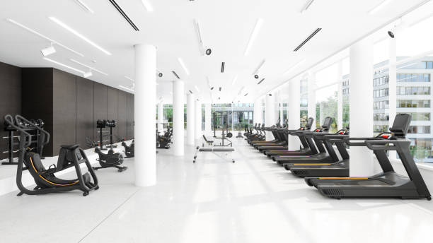 Modern Gym Interior With Treadmills, Exercise Bikes, Sports Equipments And City View Through Window stock photo