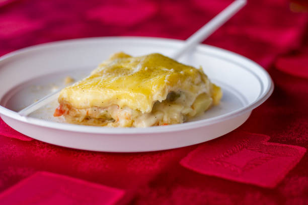 Piece of lasagne on disposable plastic plate