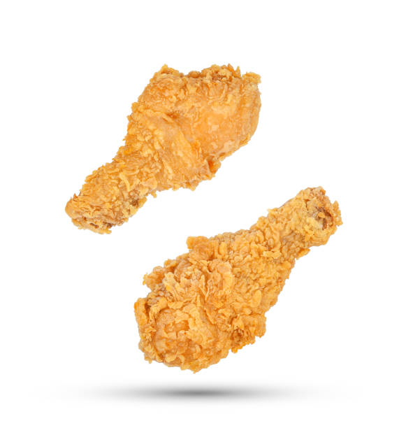 istock Fried chicken legs falling in the air isolated on white 1474307980