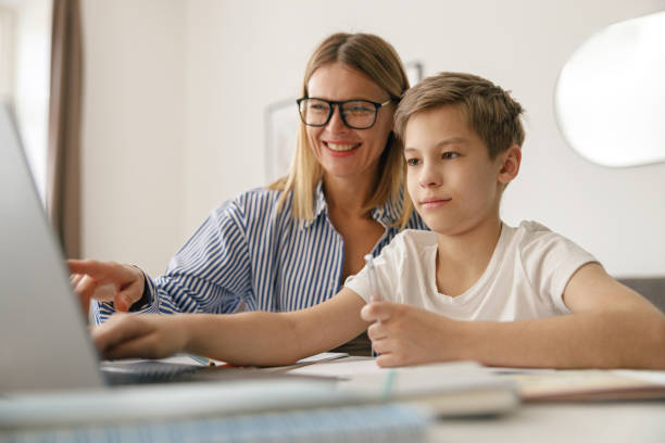 istock Happy mom and son doing homework and studying with laptop together. Home education 1474309558