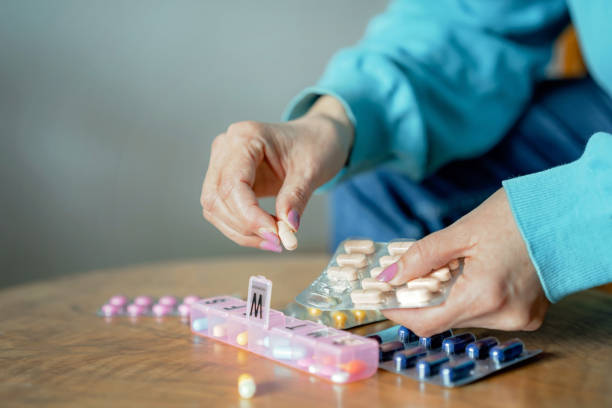 istock Unrecognizable mature woman organizing pills into a pill organizer 1474309704