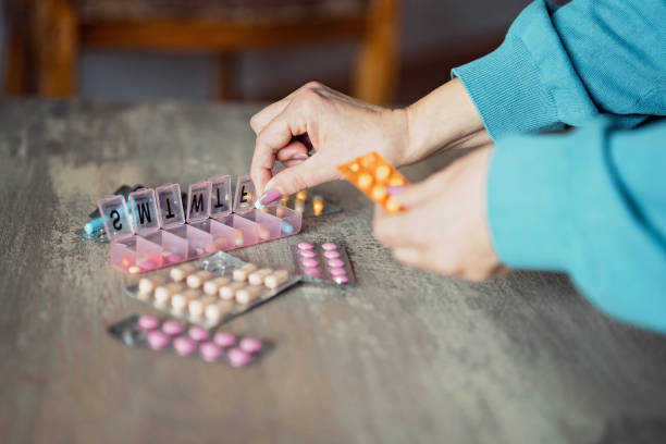 istock Unrecognizable mature woman organizing pills into a pill organizer 1474309718
