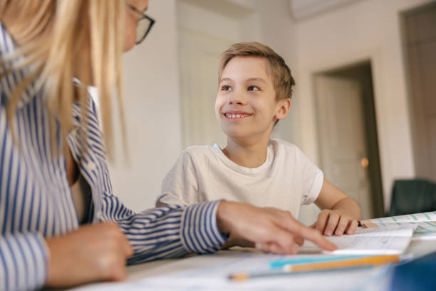 istock Close up of mom helping her son doing homework studying online using laptop in home 1474310043