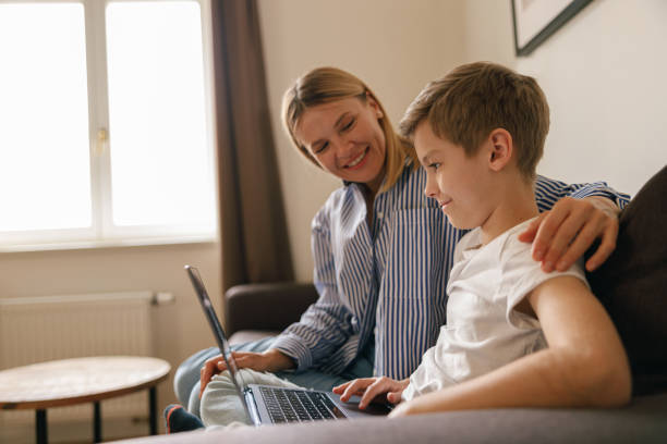 istock Mom and son looking for something on the web, games and curious newswhile sitting on sofa 1474310614