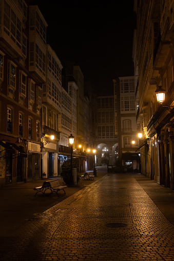 Pedestrian narrow street at night. Lights are on and there are no people, loneliness. AAtmospheric weather for hiking in a European city, Spain, A Coruna.