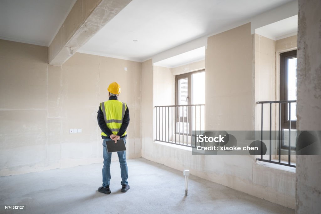 Back view of interior designer in new house Interior designer researching new home. Housing Issues, Home Improvements, Interior Decorating Rear View Stock Photo