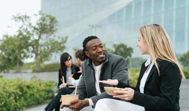 オフィスの外で昼休みを過ごす幸せなビジネスマン - two people business lunch multi ethnic group meeting ストックフォトと画像