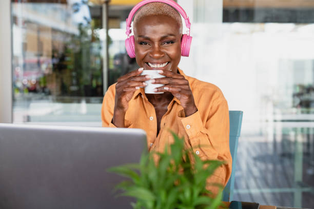istock African woman drinking coffee while using laptop in coffee shop - Digital nomad and freelance lifestyle concept 1474314984