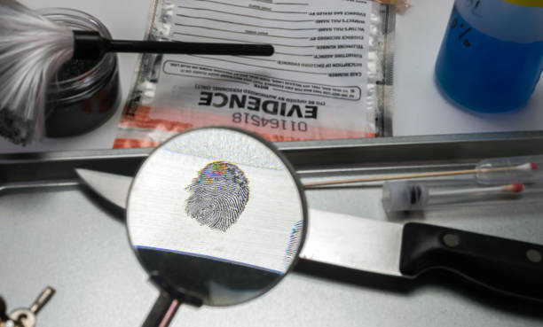 Police investigation of fingerprint on a knife, concept image stock photo