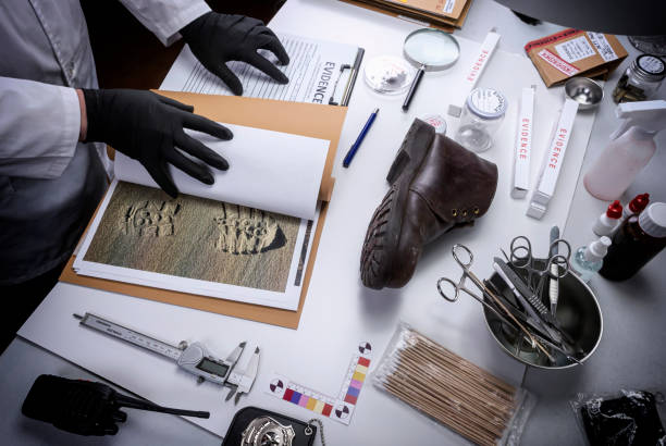 un científico de la policía investiga una banda de rodadura de cinta de zapatos implicada en el asesinato del laboratorio criminalístico, imagen conceptual - csi fotografías e imágenes de stock