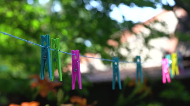 In a yard, clothespins sway in the breeze.
