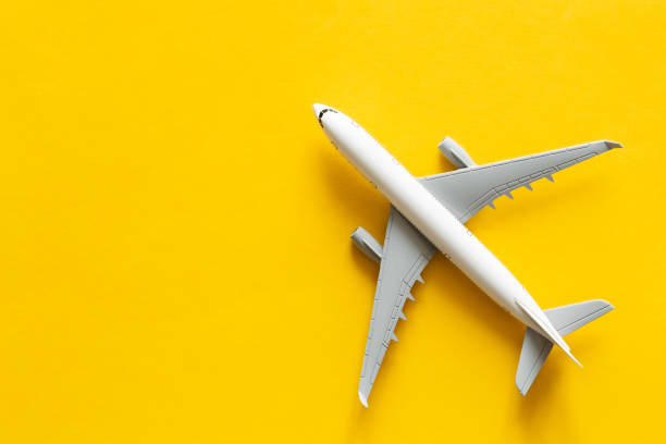 istock Airplane model on yellow background isolated, flat lay. 1474319422