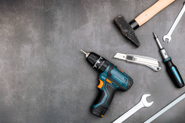 istock Hand tool set on dark board. Cordless drill, screwdriver, hammer, wrench, cutter. Flat lay, top view 1474320685