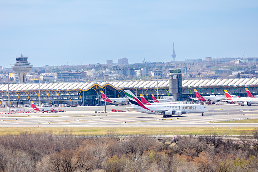 Madrid, Spain - March 14, 2023: airplanes taking off at Adolfo Suarez Madrid Barajas Airport MAD with the city skyline in the background in Madrid, Spain