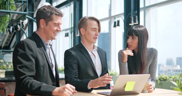 istock A group of business diverse people using laptop talking and discussing for work at modern office 1474323585