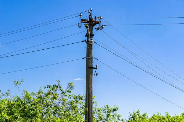 Photo of Power electric pole with line wire on colored background close up