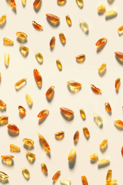 Natural gemstone amber texture background, small stones at sunlight, yellow orange color on beige. Natural mineral for jewelry. Top view Aesthetic Amber textured minimal pattern, pieces resin
