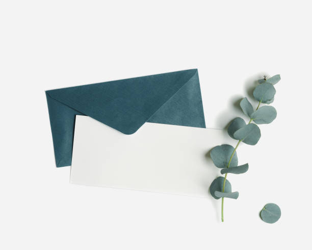 istock Teal color envelope and blank paper card mock up and branches eucalyptus leaves on white background. empty invitation on table. Minimal modern lifestyle photo. Flat lay, top view, copyspace 1474326334