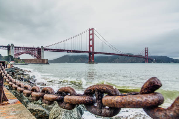 Scenic view of cloudy beach with background view of old red bridge and the cliffs in San Francisco, California