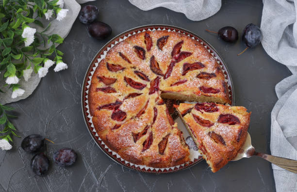 istock Homemade plums pie on round plate on gray background, top view 1474326884